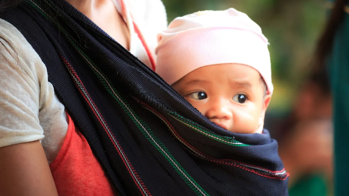 Use babywearing with an infant or small toddler to keep hands free while navigating terminals and maintaining close physical comfort